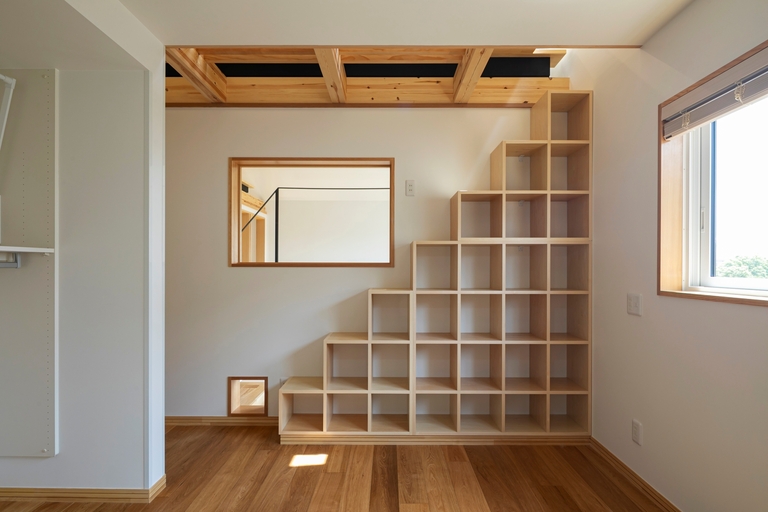 階段状の本棚と吹き抜けを見下ろせる窓。廣瀬慶二設計。